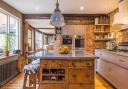 The kitchen, which is a bespoke design and has exposed brick walls