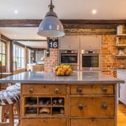 The kitchen, which is a bespoke design and has exposed brick walls
