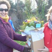 Parish councillor Jenny Walpole presents Lady Dannatt with a floral arrangement.