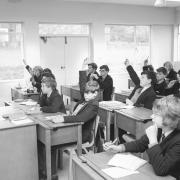 Hands raised to answer one of the teachers at Wymondham College. Date: May 10, 1965.